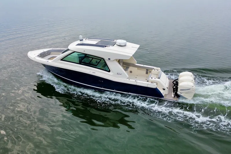 Yacht Photos Pics 2023 Scout 350 LXZ boat cruising on calm water, featuring sleek design and powerful engines.