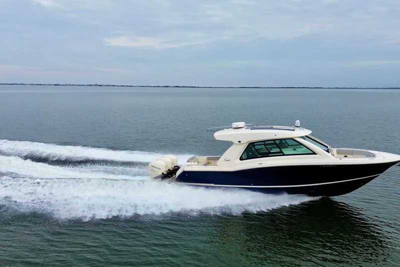  Yacht Photos Pics 2023 Scout 350 LXZ boat cruising on open water, showcasing sleek design and powerful engines.