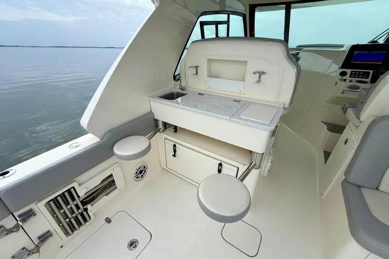  Yacht Photos Pics 2023 Scout 350 LXZ boat interior with seating and storage, overlooking calm waters.