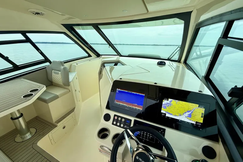  Yacht Photos Pics 2023 Scout 350 LXZ boat interior with navigation screens and seating area.