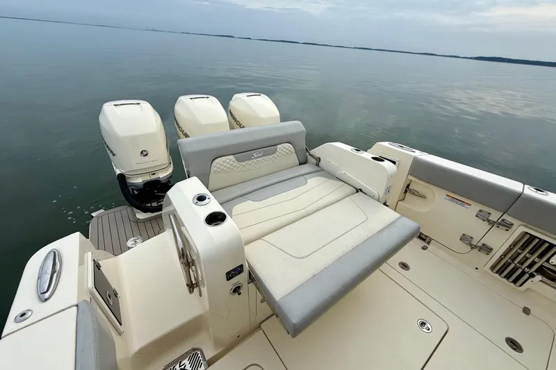  Yacht Photos Pics 2023 Scout 350 LXZ boat with triple outboard engines and spacious seating on calm water.