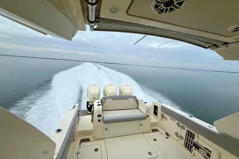  Yacht Photos Pics 2023 Scout 350 LXZ boat cruising on calm waters, showcasing powerful engines and sleek design.