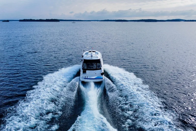  Yacht Photos Pics 2009 Sea Ray 48 Sundancer cruising on open water, leaving a wake behind.