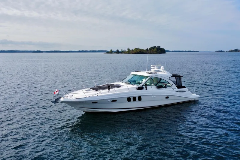  Yacht Photos Pics 2009 Sea Ray 48 Sundancer yacht cruising on a calm lake with distant islands.