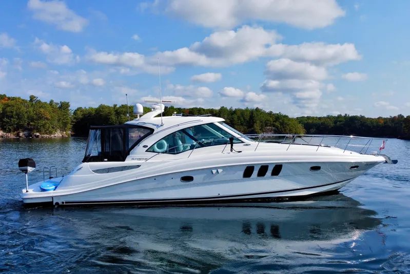  Yacht Photos Pics 2009 Sea Ray 48 Sundancer yacht on a serene lake with lush green shoreline.