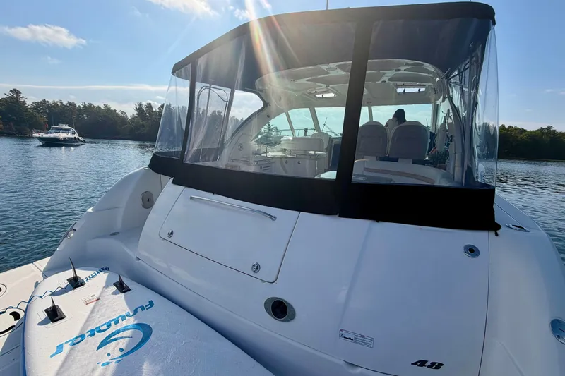  Yacht Photos Pics 2009 Sea Ray 48 Sundancer yacht on calm water, featuring a clear canopy and paddleboard.