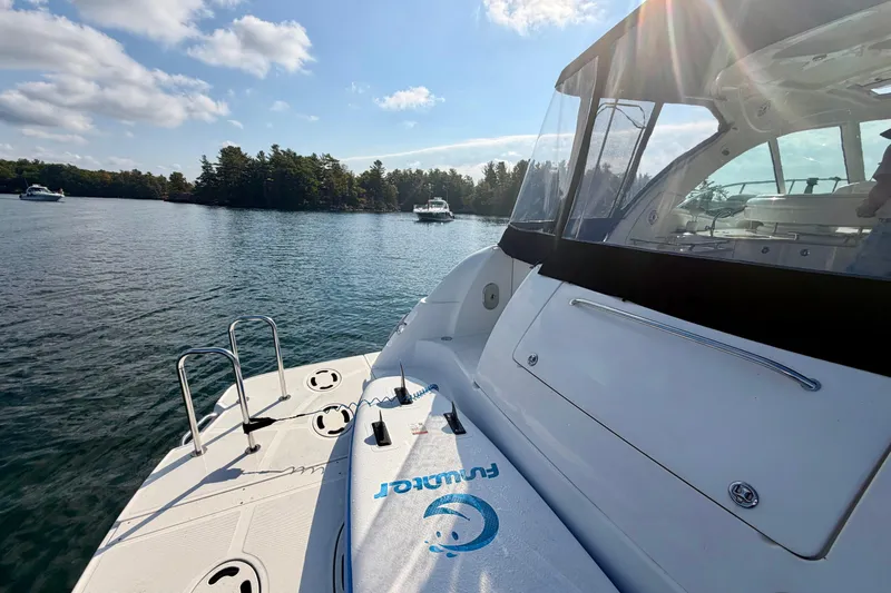  Yacht Photos Pics 2009 Sea Ray 48 Sundancer yacht on serene lake with clear skies and distant boats.