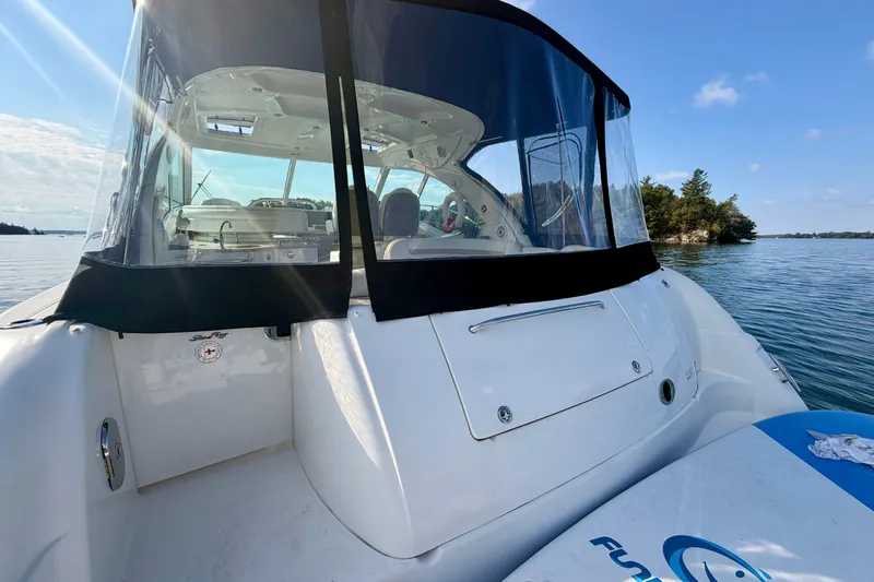  Yacht Photos Pics 2009 Sea Ray 48 Sundancer yacht on calm water, clear sky, and scenic shoreline.