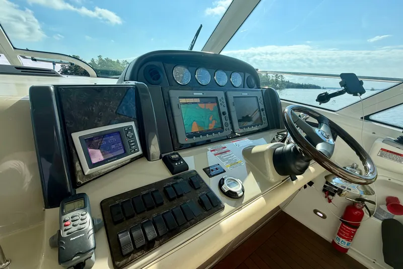  Yacht Photos Pics 2009 Sea Ray 48 Sundancer helm with advanced navigation systems and steering wheel, overlooking serene waters.