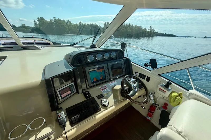  Yacht Photos Pics 2009 Sea Ray 48 Sundancer helm with navigation equipment, steering wheel, and scenic water view.
