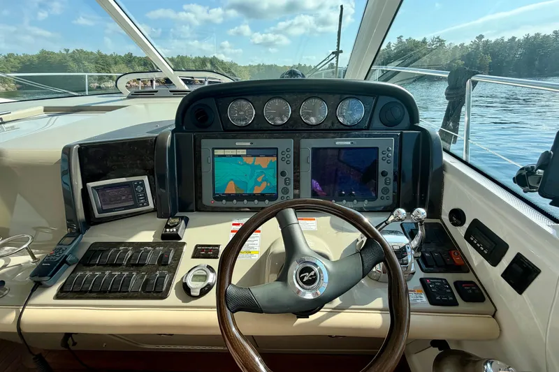  Yacht Photos Pics 2009 Sea Ray 48 Sundancer helm with navigation screens and controls on a sunny day.