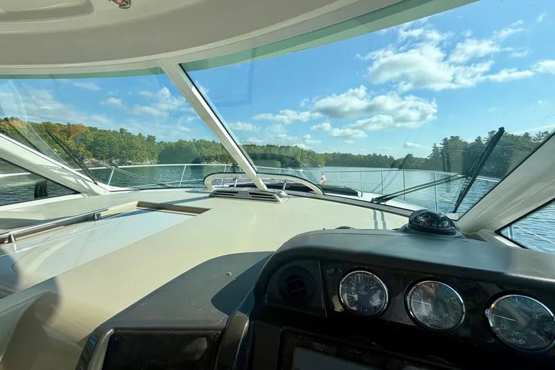  Yacht Photos Pics 2009 Sea Ray 48 Sundancer yacht cockpit view with scenic lake and forest backdrop.