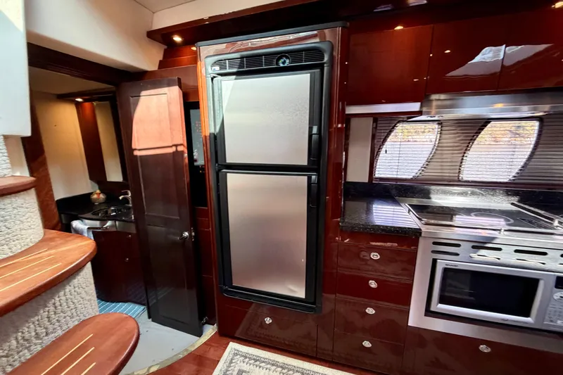  Yacht Photos Pics Luxurious 2009 Sea Ray 48 Sundancer yacht kitchen with stainless steel appliances and rich wood cabinetry.