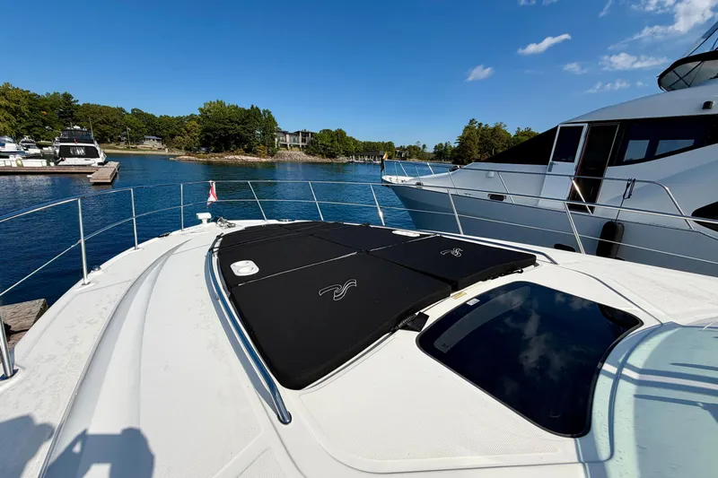  Yacht Photos Pics 2009 Sea Ray 48 Sundancer yacht docked in a scenic marina under clear blue skies.