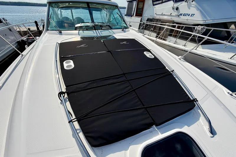  Yacht Photos Pics 2009 Sea Ray 48 Sundancer yacht with black sunpad on deck, docked beside another boat.