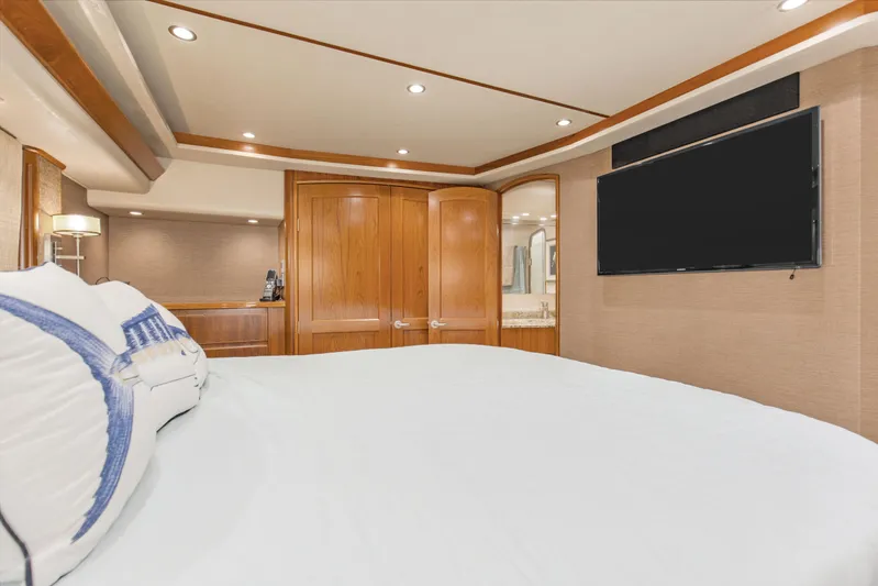 Bandito Yacht Photos Pics Luxurious bedroom interior of 2015 Viking 70 Convertible yacht with TV and wooden accents.