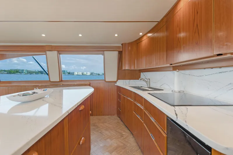 Bandito Yacht Photos Pics Luxurious kitchen interior of 2015 Viking 70 Convertible yacht with wooden cabinetry and marble countertops.