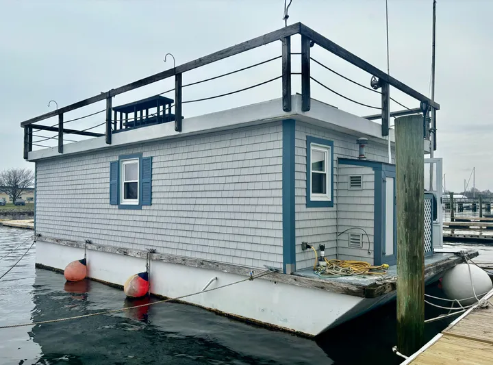  Yacht Photos Pics Custom 1990 houseboat with blue trim, docked at marina, featuring upper deck and buoy attachments.