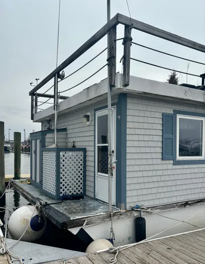  Yacht Photos Pics Custom 1990 houseboat with blue shutters and rooftop deck, docked at a marina.
