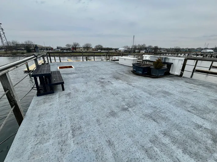 Yacht Photos Pics Rooftop view of a 1990 custom houseboat with benches and potted plants.