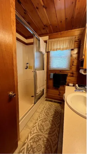  Yacht Photos Pics Wood-paneled houseboat bathroom with shower, sink, and decorative rug, Custom model, 1990.