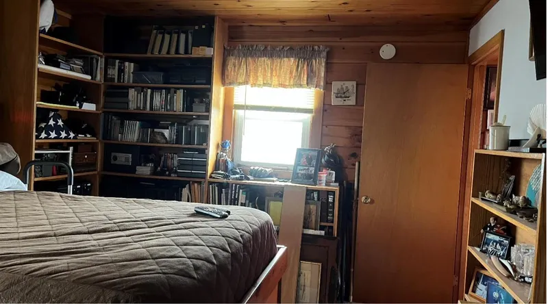  Yacht Photos Pics Cozy houseboat bedroom with wooden shelves, books, and a window. Custom model, 1990.