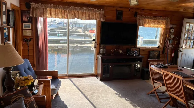  Yacht Photos Pics Cozy 1990 custom houseboat interior with waterfront view, wooden decor, and comfortable seating.
