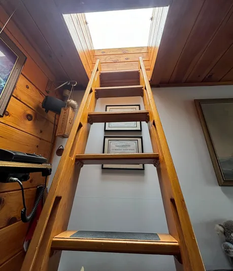  Yacht Photos Pics Wooden ladder leading to skylight in a 1990 custom houseboat interior.
