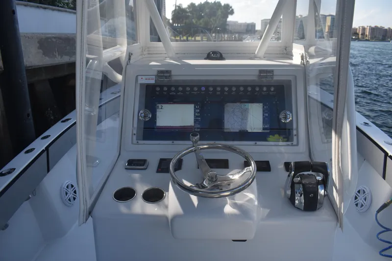 Pamela Ann Yacht Photos Pics 2017 Conch 30 boat helm with steering wheel, navigation display, and controls.