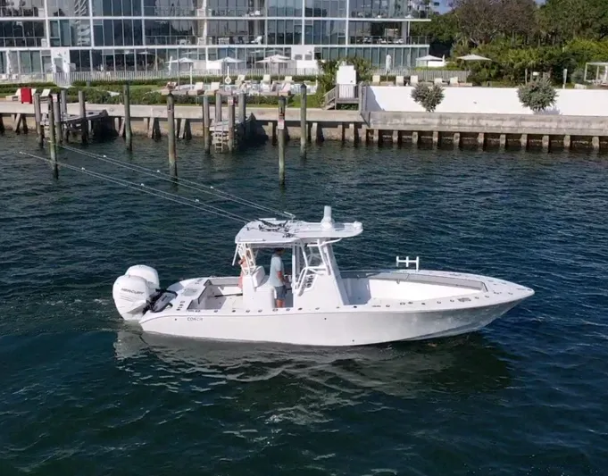 Pamela Ann Yacht Photos Pics 2018 Conch 30 boat cruising near a modern waterfront building.