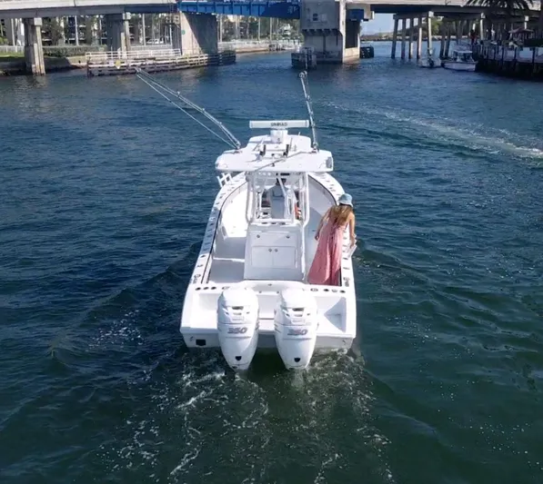 Pamela Ann Yacht Photos Pics 2018 Conch 30 boat cruising under a bridge with a person on deck.