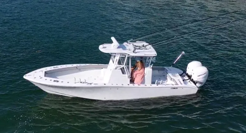 Pamela Ann Yacht Photos Pics 2018 Conch 30 boat on water with dual engines and a person at the helm.