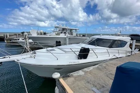  Yacht Photos Pics 2013 Uniesse 49 EXPRESS yacht docked at marina under cloudy sky.