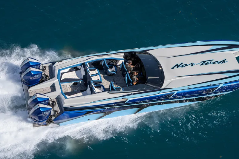  Yacht Photos Pics 2026 Nor-Tech 4000 Super Catamaran speeding on blue water, showcasing sleek design and powerful engines.