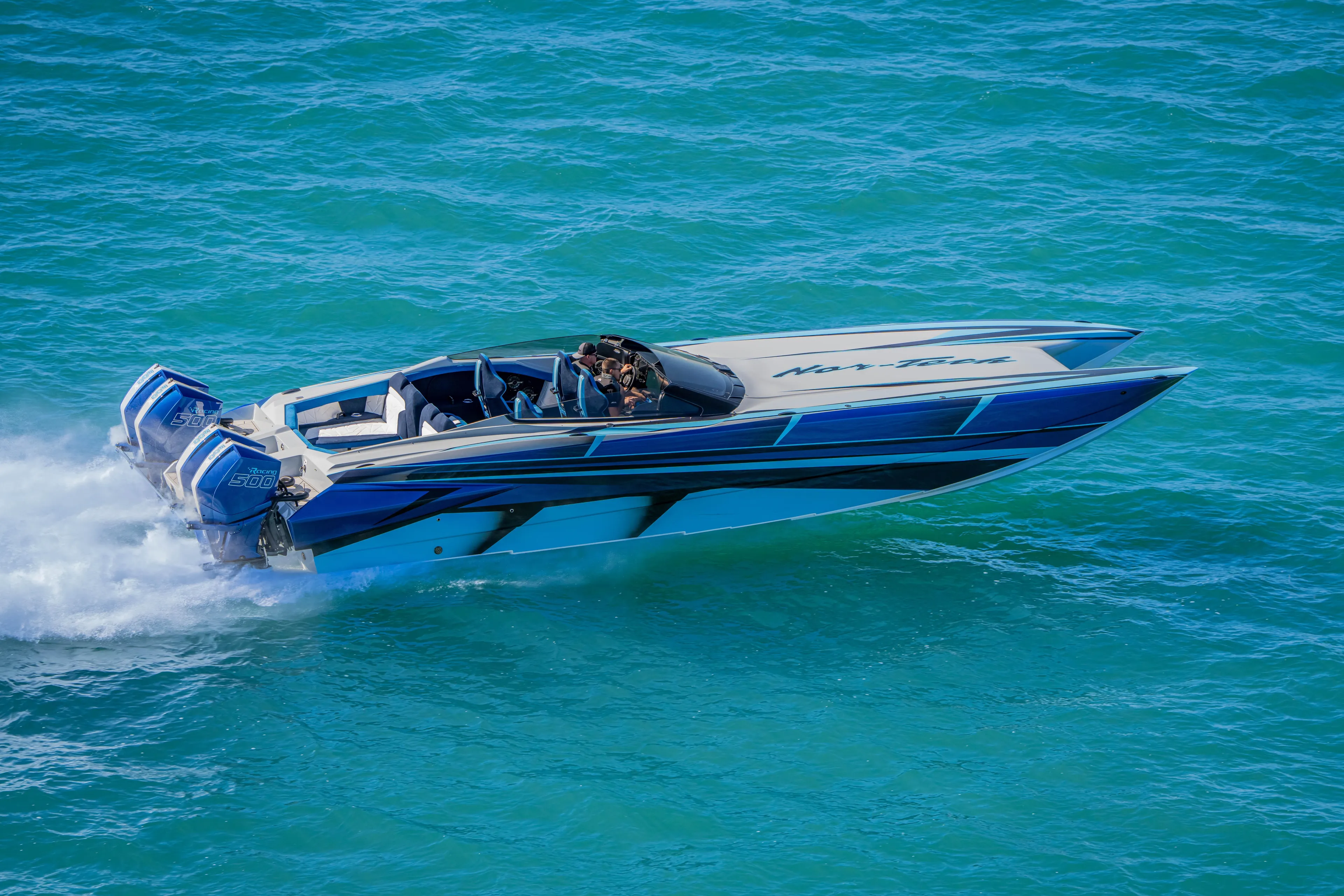  Yacht Photos Pics 2026 Nor-Tech 4000 Super Catamaran speeding on turquoise water, showcasing sleek design and power.