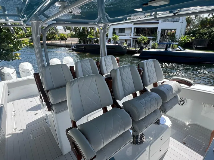 Nomad Yacht Photos Pics Luxurious seating on a 2021 Freeman 42 LR boat, docked by waterfront homes.