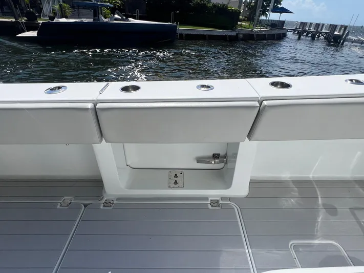 Nomad Yacht Photos Pics 2021 Freeman 42 LR boat deck with rod holders, docked by the water.