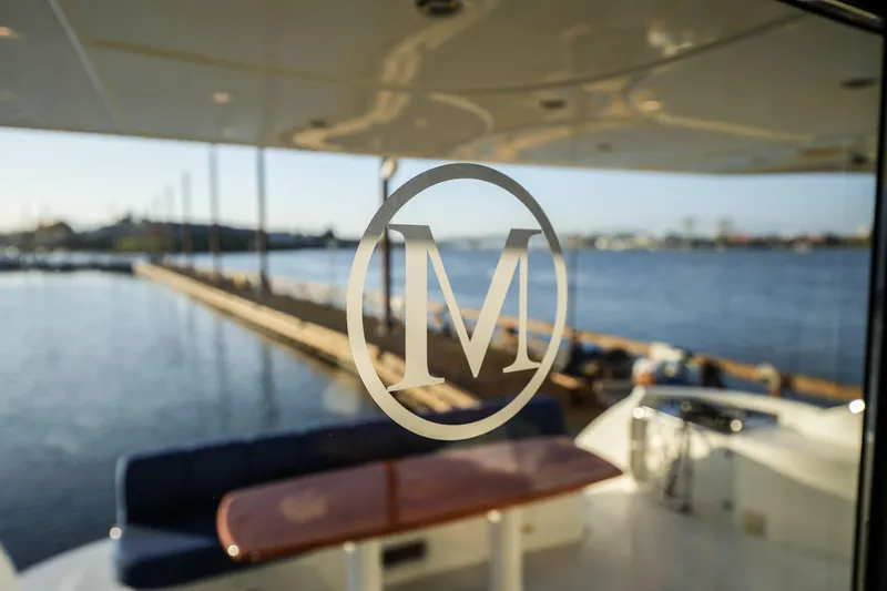  Yacht Photos Pics Luxury yacht interior with "M" logo, Marquis 65, 2006 model, overlooking serene waterfront.