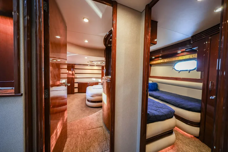  Yacht Photos Pics Luxurious interior of a 2006 Marquis 65 yacht with elegant wood finishes and cozy sleeping quarters.