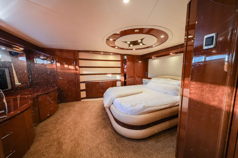  Yacht Photos Pics Luxurious bedroom interior of 2006 Marquis 65 yacht with elegant wood finishes and modern design.