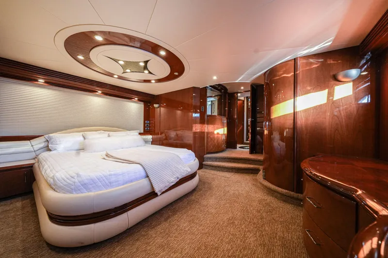  Yacht Photos Pics Luxurious bedroom interior of 2006 Marquis 65 yacht with elegant wood finishes and modern lighting.
