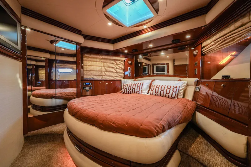  Yacht Photos Pics Luxurious bedroom interior of a 2006 Marquis 65 yacht with elegant wood finishes.