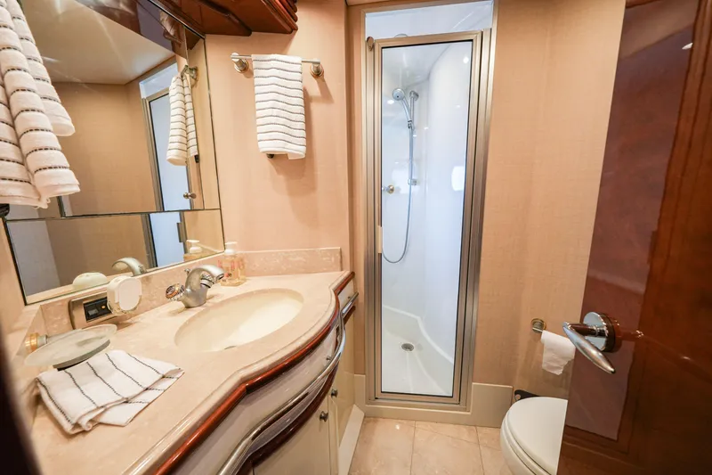  Yacht Photos Pics Luxurious bathroom in 2006 Marquis 65 yacht with shower, sink, and elegant fixtures.