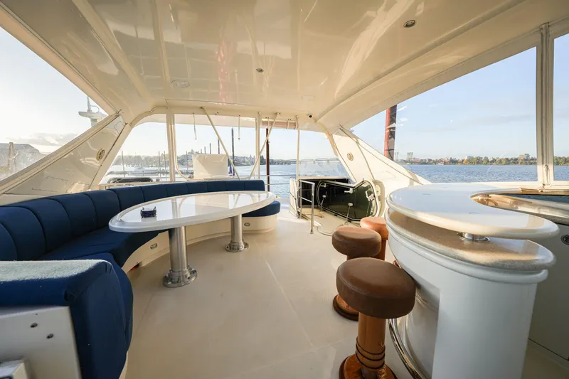  Yacht Photos Pics Luxurious 2006 Marquis 65 yacht interior with elegant seating and bar area, overlooking serene waters.