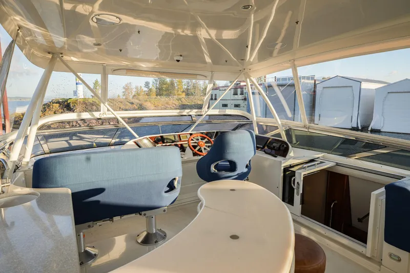  Yacht Photos Pics Interior view of 2006 Marquis 65 yacht helm with blue seating and panoramic windows.