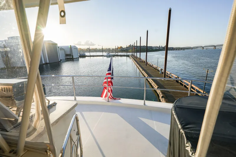  Yacht Photos Pics 2006 Marquis 65 yacht docked at marina with American flag, sunny waterfront view.