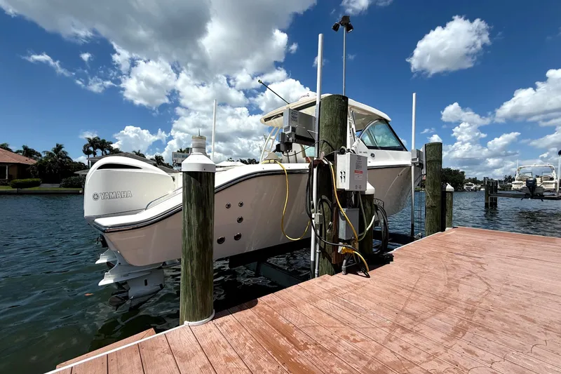  Yacht Photos Pics 2016 Pursuit DC 325 Dual Console boat docked with Yamaha engine, under a clear blue sky.