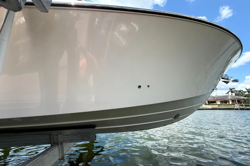  Yacht Photos Pics 2016 Pursuit DC 325 Dual Console boat on lift, near waterfront homes.