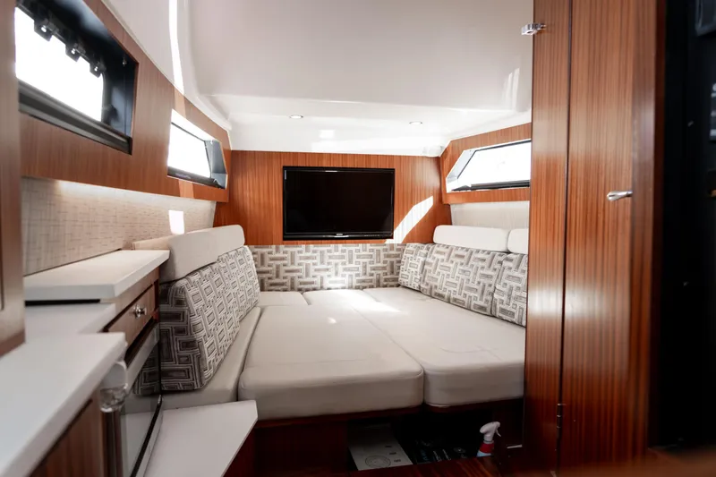 Nomad Yacht Photos Pics 2022 Pursuit S 428 Sport cabin interior with modern seating and TV.