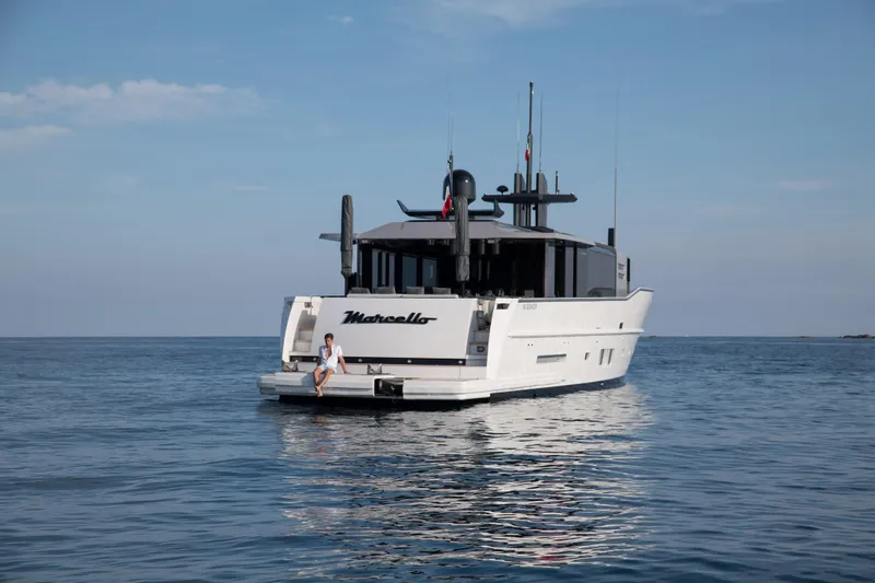 Marcello Yacht Photos Pics 2015 Arcadia Yachts Arcadia 85 on calm sea, rear view, person sitting on deck.